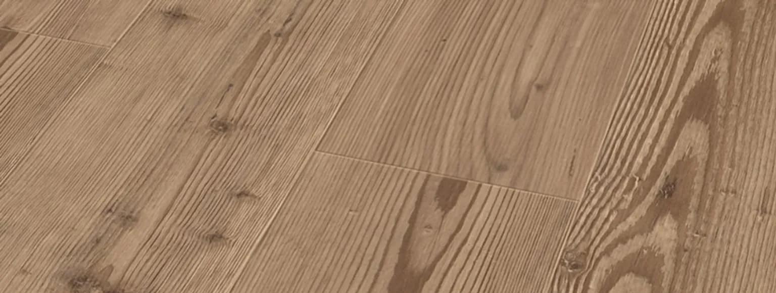 Detailaufnahme eines hellbraunen Laminatbodens mit Holzmaserung und Oberflächenstruktur.