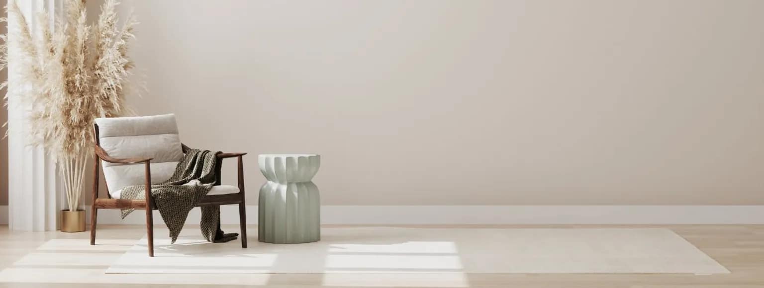 Modernes Wohnzimmer mit neutralem Sessel, hellem Vinylboden, Beistelltisch und Pampasgras.