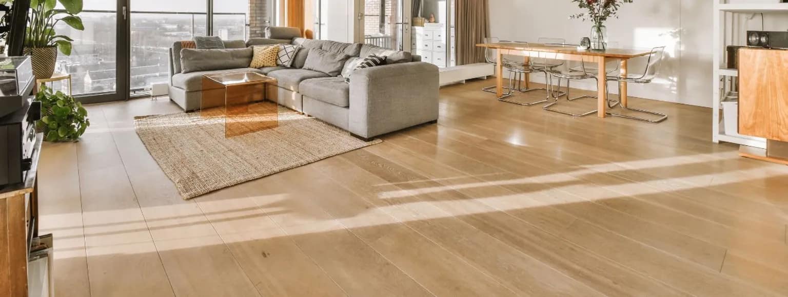 Wohn- und Esszimmer mit großen Fenstern, hellen Wänden und Holzparkettböden.