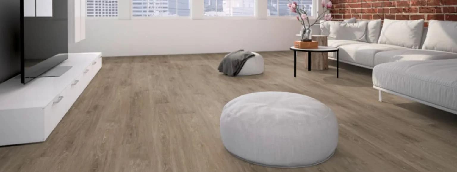 Wohnzimmer mit Vinylboden, weißem Sofa und großen Fenstern, die natürliches Licht hereinlassen.